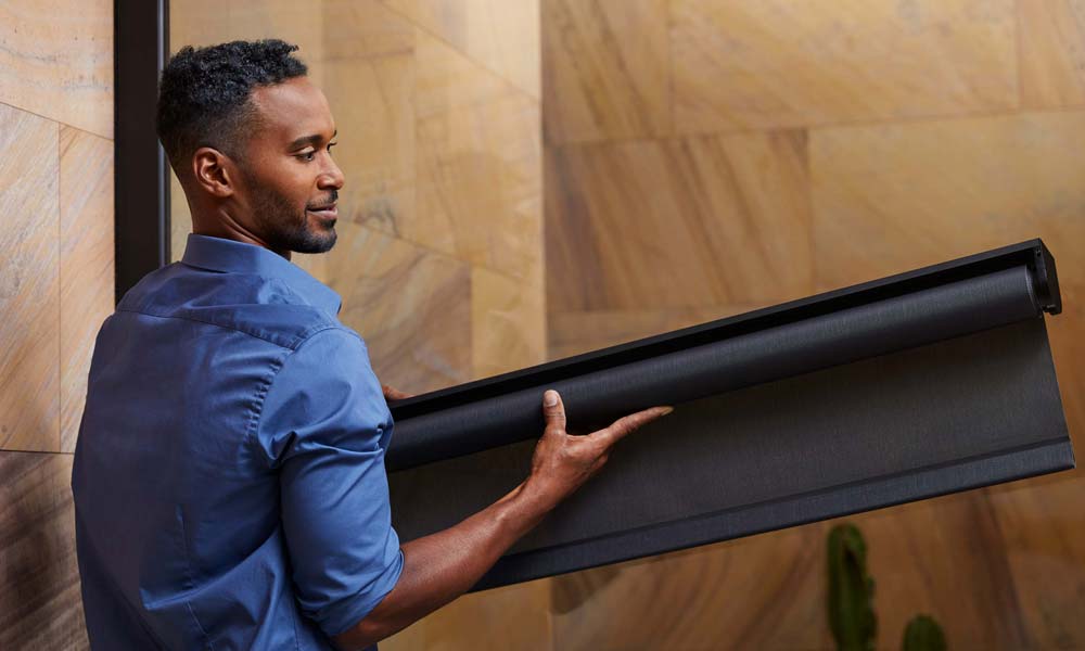 man holding a Savant Shade about to be installed