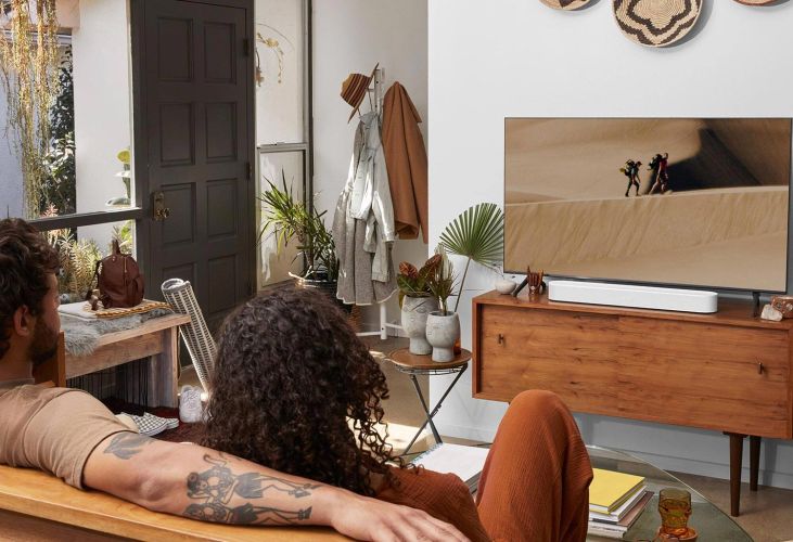 Couple on their backs watching TV with Sonos arch speaker